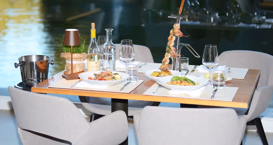 Table set with fish and pasta dishes right by the water of the Issinger Weiher